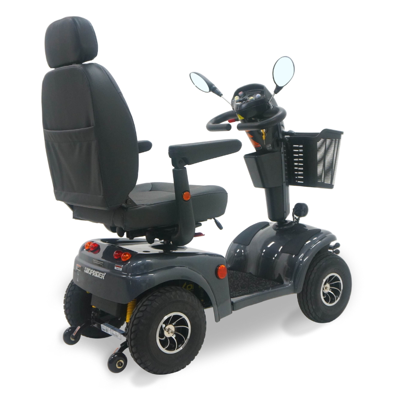 Rear of Gray Expedition XL4 4-wheel mobility scooter with a high-back captain’s seat, front basket, rearview mirrors, headlight, and all-terrain tires, shown on a white background.