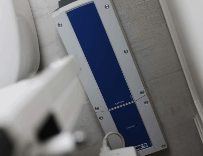 Wall Mounted Batter Pack  On Wall- TILT® Toilet Incline Lift by EZ-Access | Wheelchair LIberty