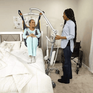 Woman Lift by Caregiver From Bed - Carina350 Mobile Patient Lifts By Handicare | Wheelchair Liberty