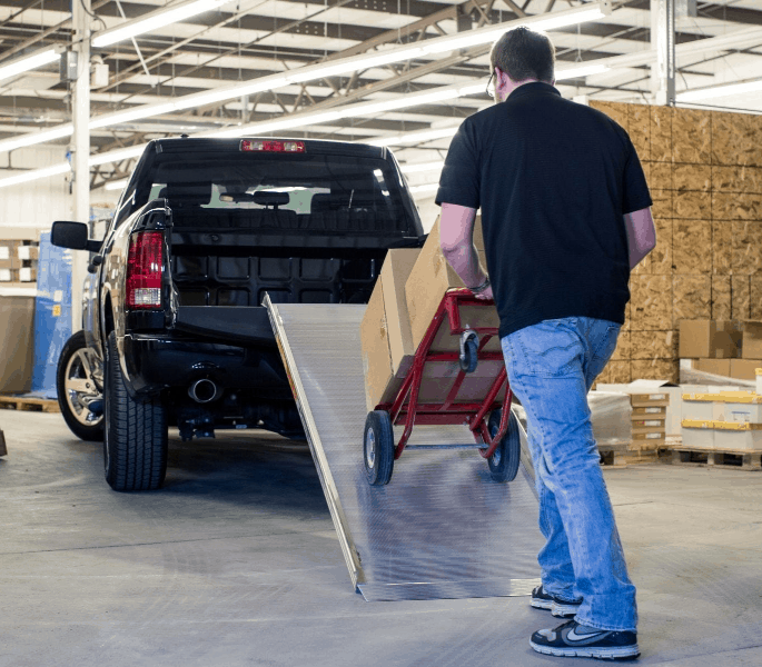 Man Loading Packages on a pick-up truck using TRAVERSE™ Portable Walk ...